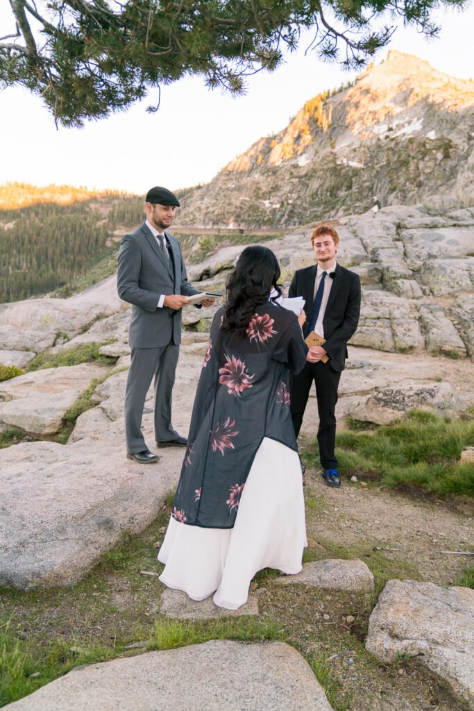 Mixed POC elopement couple exchanging vows in a forested area overlooking Donner Lake near Lake Tahoe, California.