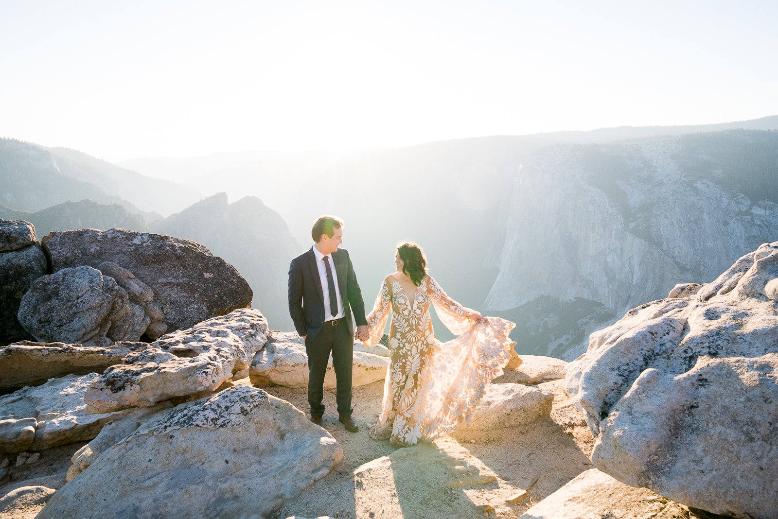A couple at an Elopement Photo session at Taft Point, Yosemite National Park overlooking the valley and rim trail with the beginning of a beautiful sunset