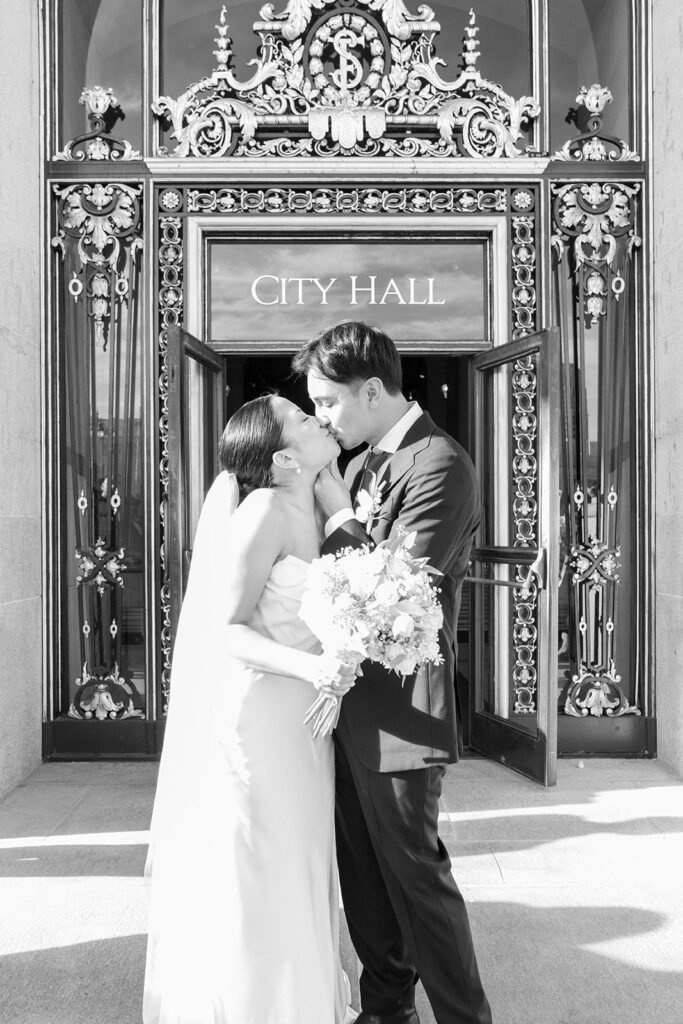 Newlyweds kiss in front of San Francisco City Hall.