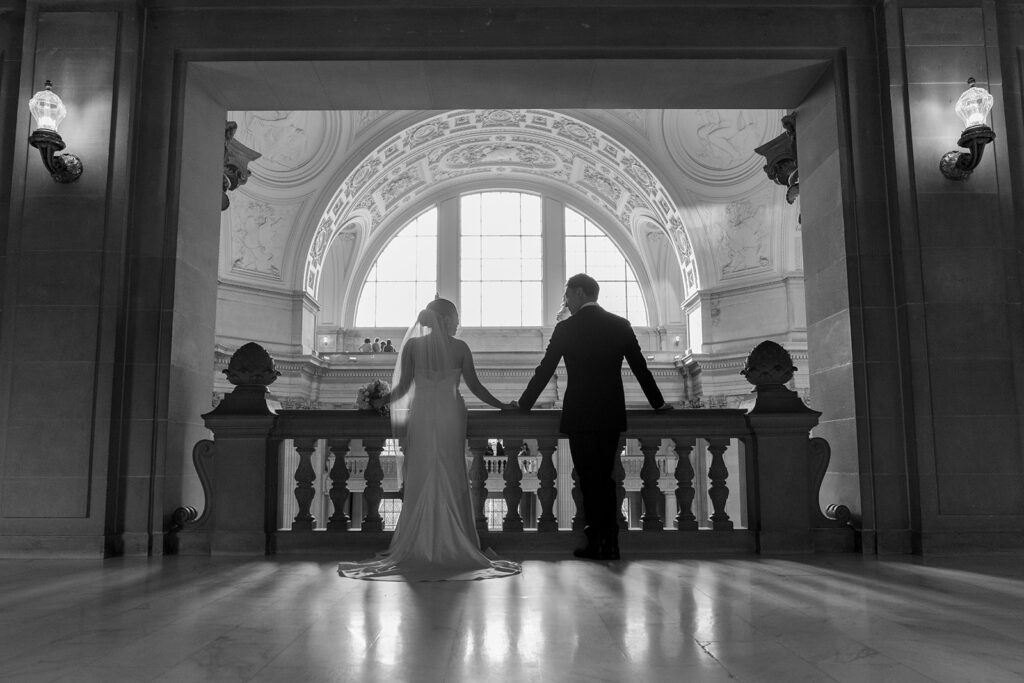 Newlyweds on the balcony at SF City Hall wedding.
